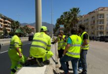 Se pone fin a un problema histórico del alumbrado en la A-7 a su paso por Sabinillas Trabajadores y técnicos con chalecos reflectantes conversan junto a una carretera urbana