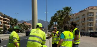 Se pone fin a un problema histórico del alumbrado en la A-7 a su paso por Sabinillas Trabajadores y técnicos con chalecos reflectantes conversan junto a una carretera urbana